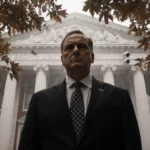 Brown University administrator standing under leafy canopy on campus with autumn mist and ivy building in background