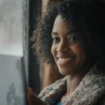 Customer support agent speaking with client on phone with headset and help desk sign in office.