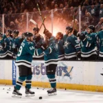 Wyatt Johnston and Roope Hintz high‑fiving after victory with hockey sticks held and grinning under orange‑pink arena lights