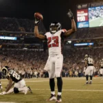 Bijan Robinson lifts the football in a pose while Falcons fans cheer and the scoreboard shows a 27-24 Monday Night Football w