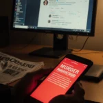 Phone screen shows bold tweet with red glow and crumpled newspaper clipping titled MURDER ROB REINER on dim newsroom desk