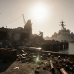 US naval vessel looming over damaged dock with sun-kissed shore and scattered debris