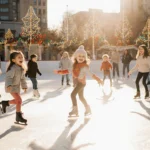Children skating on an ice rink with bright smiles under a blazing Texas summer sun and twinkling lights.