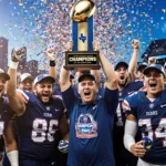 High school football players cheer around a championship trophy with confetti and a coach beside them blue stadium backdrop