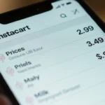 Smartphone screen shows Instacart price discrepancy with $2.99 $3.49 $4.99 side by side under soft natural light
