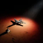 Military aircraft flying low over desert horizon with spotlight and church silhouette in foreground.