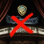 College student studying at desk with laptop and coffee surrounded by books and notes.