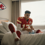 Patrick Mahomes sits on a bed with a bandaged leg and ice pack on his knee window glow and Chiefs logo on bedside table