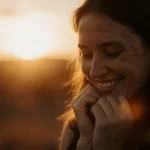 Rachael Carpani smiles with warm golden light and a soft-focus Australian sunset behind her