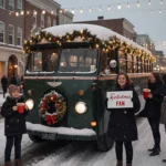 Fans line up to take a photo with a 1950s bus with garlands on a Connecticut square with winter lights
