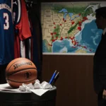 Basketball rests on trash can with crumpled betting slips and jerseys hanging behind