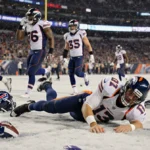 Bo Nix lies on field clutching injured ankle with concerned Broncos teammates and departing Bills players in background
