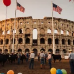 Cowboys and cattle gather outside the historic Coliseum at sunset with American flags flying overhead and volunteers preparin