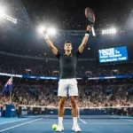 Novak Djokovic celebrating victory at Australian Open with crowd cheering and 100th win scoreboard behind him