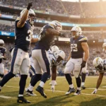 Drake Maye celebrating victory with Christian Gonzalez as defeated Chargers players sit behind them at SoFi Stadium