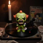 Funko Pop Pickle Dad stares with twisted face from record player with flickering candle and horror posters behind
