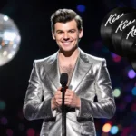 Harry Styles performing on stage with shimmering silver jumpsuit and vinyl records showing Kiss All Time