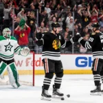 Ilya Mikheyev celebrating second goal with puck and high-fives from teammates near dejected Dallas goalie in cheering crowd