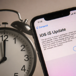 iPhone screen shows iOS update prompt with subtle gradient and a ticking clock on muted gray background.