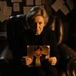 Kathleen Kennedy holding worn Han Solo photo with golden light showing contemplation and production notes nearby