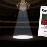 Spotlight shining on cancelled gala poster with dim chandelier and blurred Kennedy Center protest words