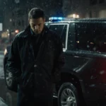 Lenny Dykstra standing beside his car with rain-soaked street and police lights reflecting.