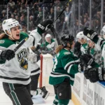 Marino celebrates with Utah Mammoth teammates after scoring with Dallas Stars bench showing frustration behind them