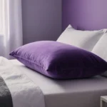 Plush Purple pillow rests on bedside table with soft purple walls and natural sunlight streaming through window