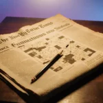 Pencil hovering over torn newspaper page revealing cryptic NYT Connections puzzle with warm golden light