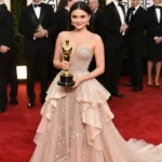 Selena Gomez holds Golden Globe trophy with sparkling gown and flowing train on red carpet