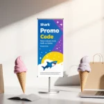 Shark promo banner stands tall with colorful shopping bags and laptops scattered nearby