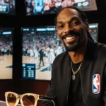 Snoop Dogg analyzes NBA game footage with live stats and cheering crowd behind him