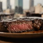 Sizzling steak beckons with golden glow on plate and city skyline in blurred background for meal kit