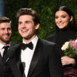Timothée Chalamet accepting his award with a warm smile and lush greenery behind him while Josh Safdie holds award ceremony.